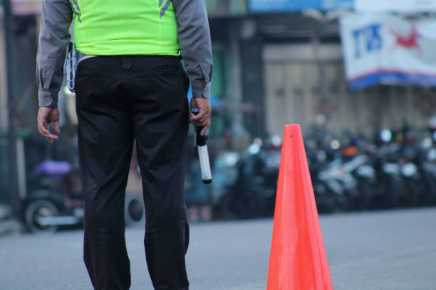 Traffic marshal in high-visibility vest managing vehicle flow on-site, representing Albiz Security’s professional traffic management and site access control services in London.