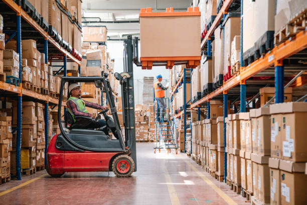 Warehouse workers operating a forklift and managing inventory, supported by Albiz Security’s warehouse and logistics security services in London.